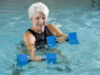 Eine Seniorin macht Wassergymnastik.