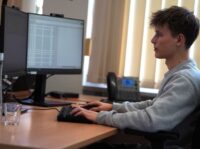 Ein junger Auszubildender arbeitet am PC.