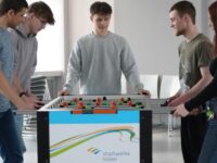 Fünf Auszubildende kickern.