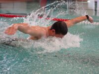 Ein junger Auszubildender schwimmt im Pool.