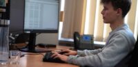 Ein junger Auszubildender arbeitet am PC.