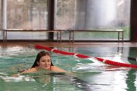 Eine junge Auszubildende schwimmt im Pool.