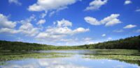 Ihre Wärmepumpe als Wertanlage für die Zukunft Blauer Himmel mit Wolken, die sich auf einer Wasserfläche spiegeln