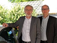 Die beiden Geschäftsführer Schneider und Heuberger auf dem Werksgelände, im Hintergrund eine Photovoltaikanlage.