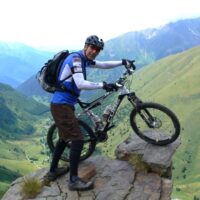 Doktor Döring steht mit seinem Fahrrad in den Alpen.