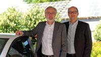 Die beiden Geschäftsführer Schneider und Heuberger auf dem Werksgelände, im Hintergrund eine Photovoltaikanlage.